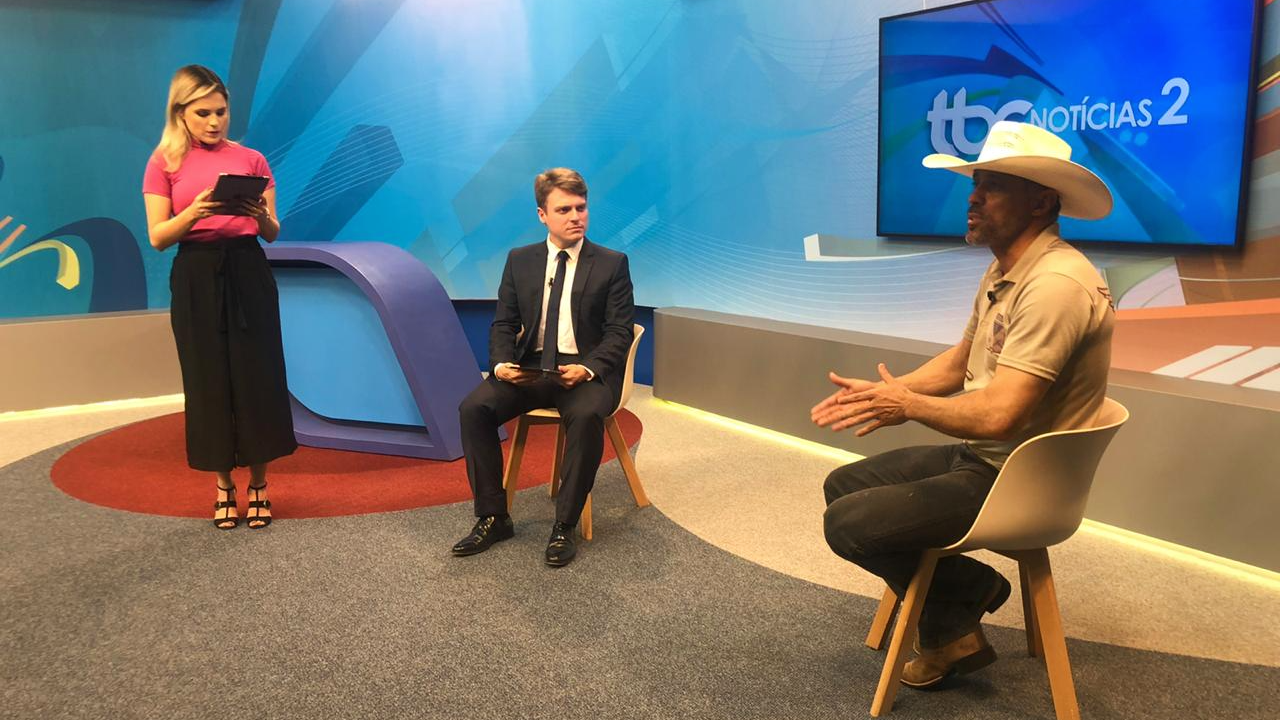 Foto do deputado estadual Amauri Ribeiro no estúdio do TBC2 com os apresentadores Danuza Azevedo e Guilherme Rigonato