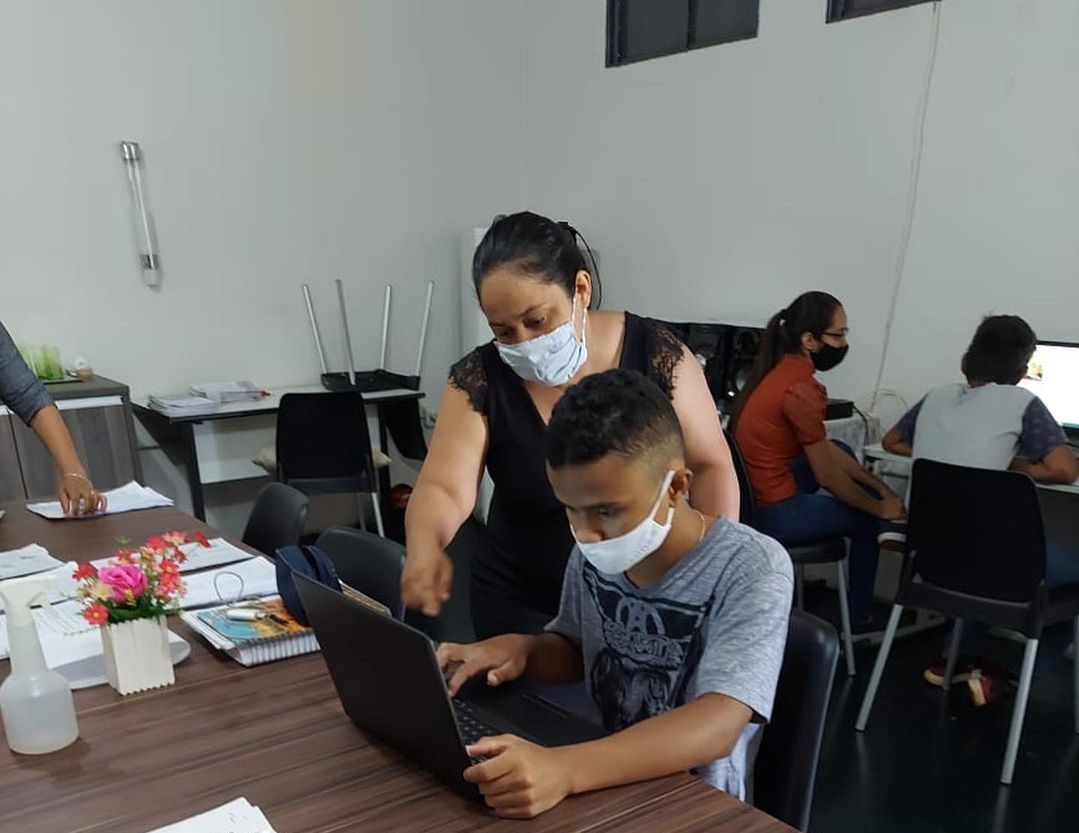 Professora ajuda aluno a realizar avaliação diagnóstica na Escola Estadual José Madalena, de Maurilândia