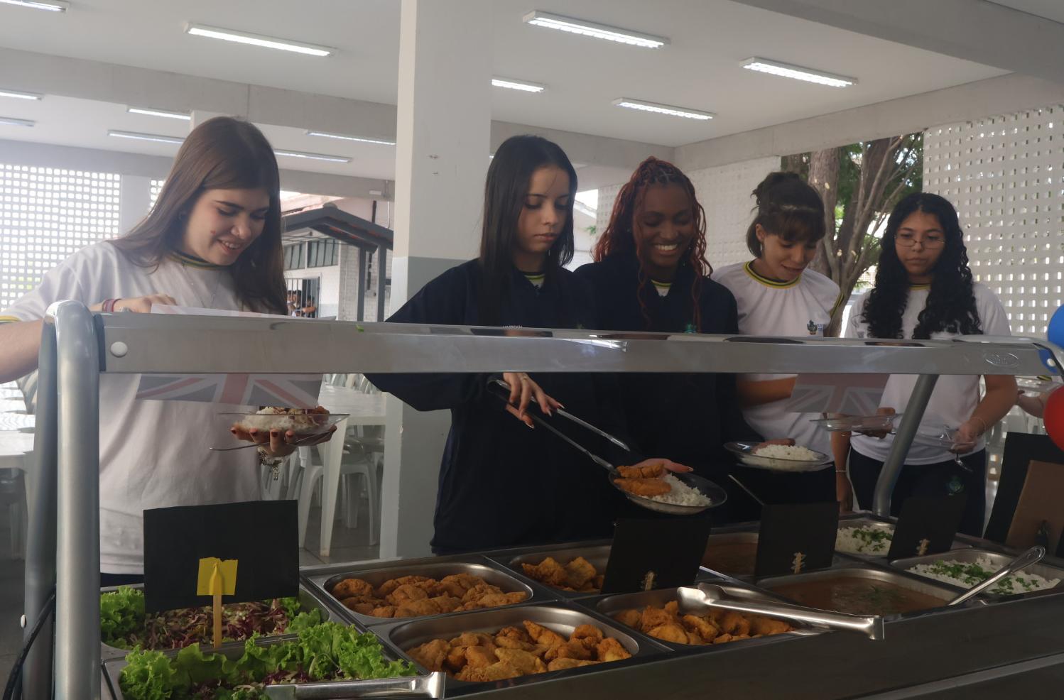 Alunas do CEPI Sudoeste na fila do almoço temático da Inglaterra. (Foto: Seduc/GO)