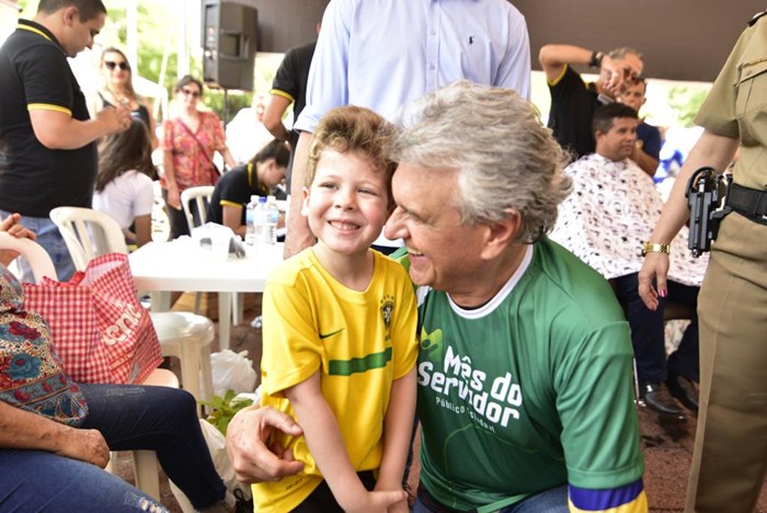 Governador Caiado abraçando um garotinho durante as festividades do dia do servidor público, na praça Cívica.