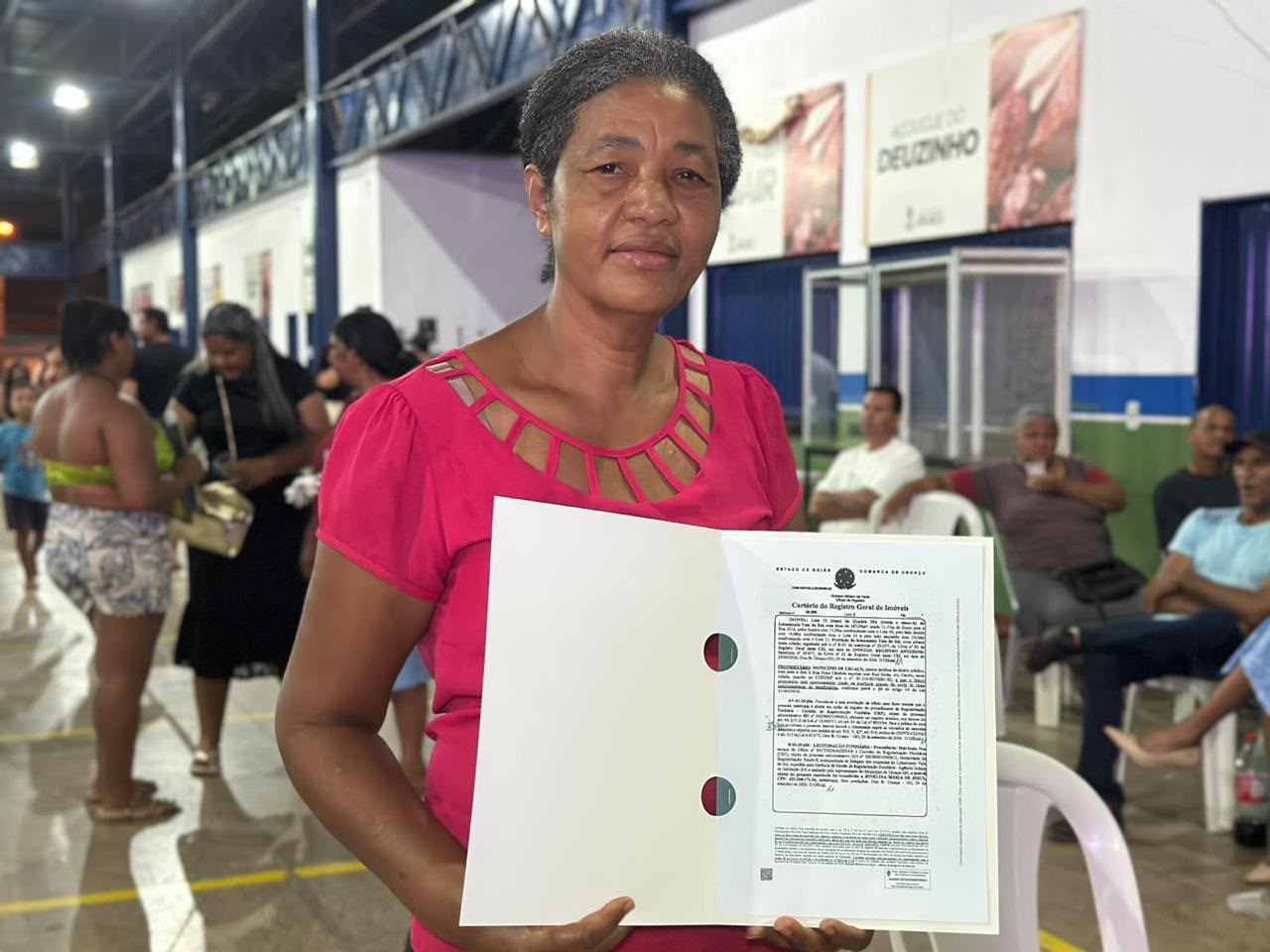 Agehab põe fim à espera de 70 anos por escritura em Acreúna - mulher negra segurando escritura